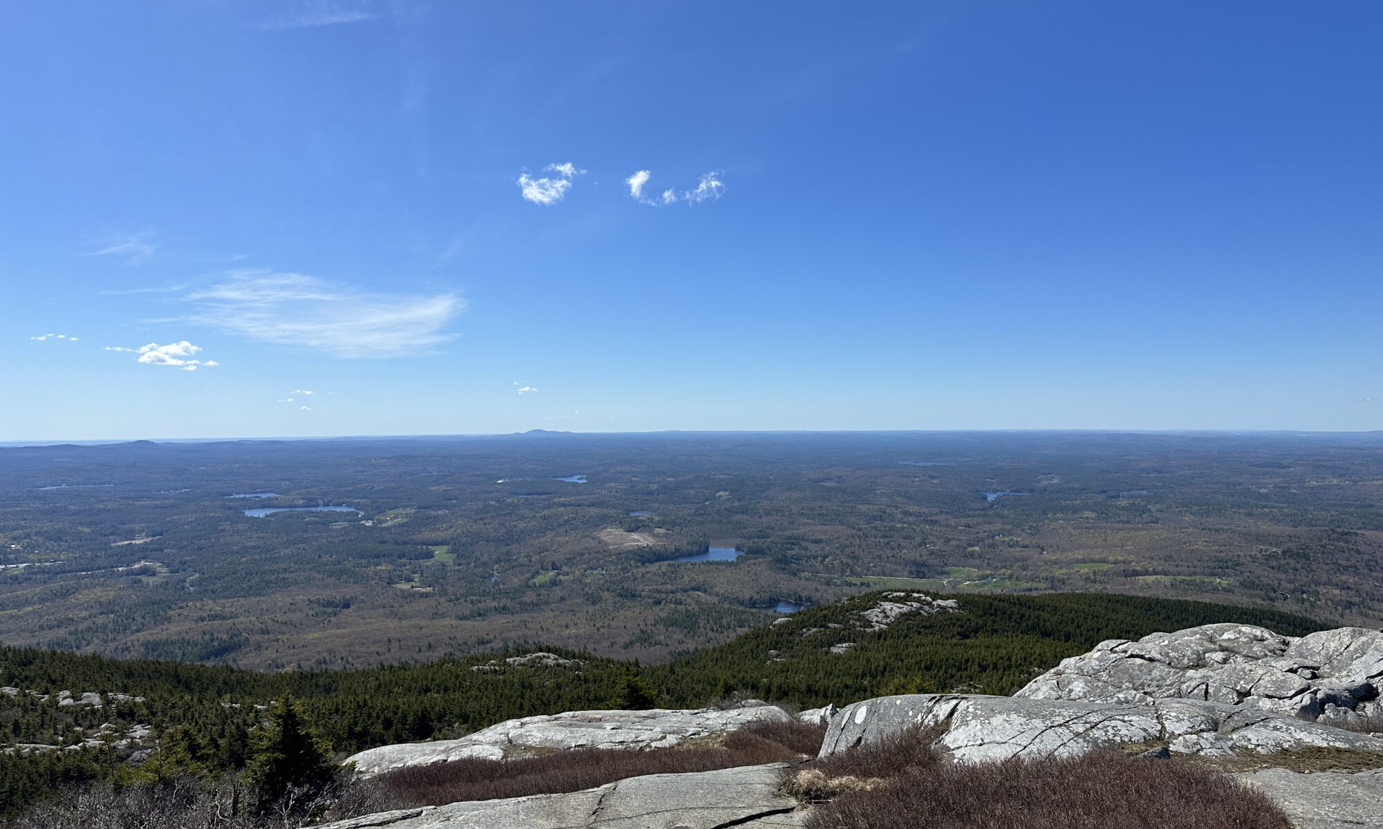 This image is the peak of Mt. Monadnock where you could see blue skies, lakes, and nature!